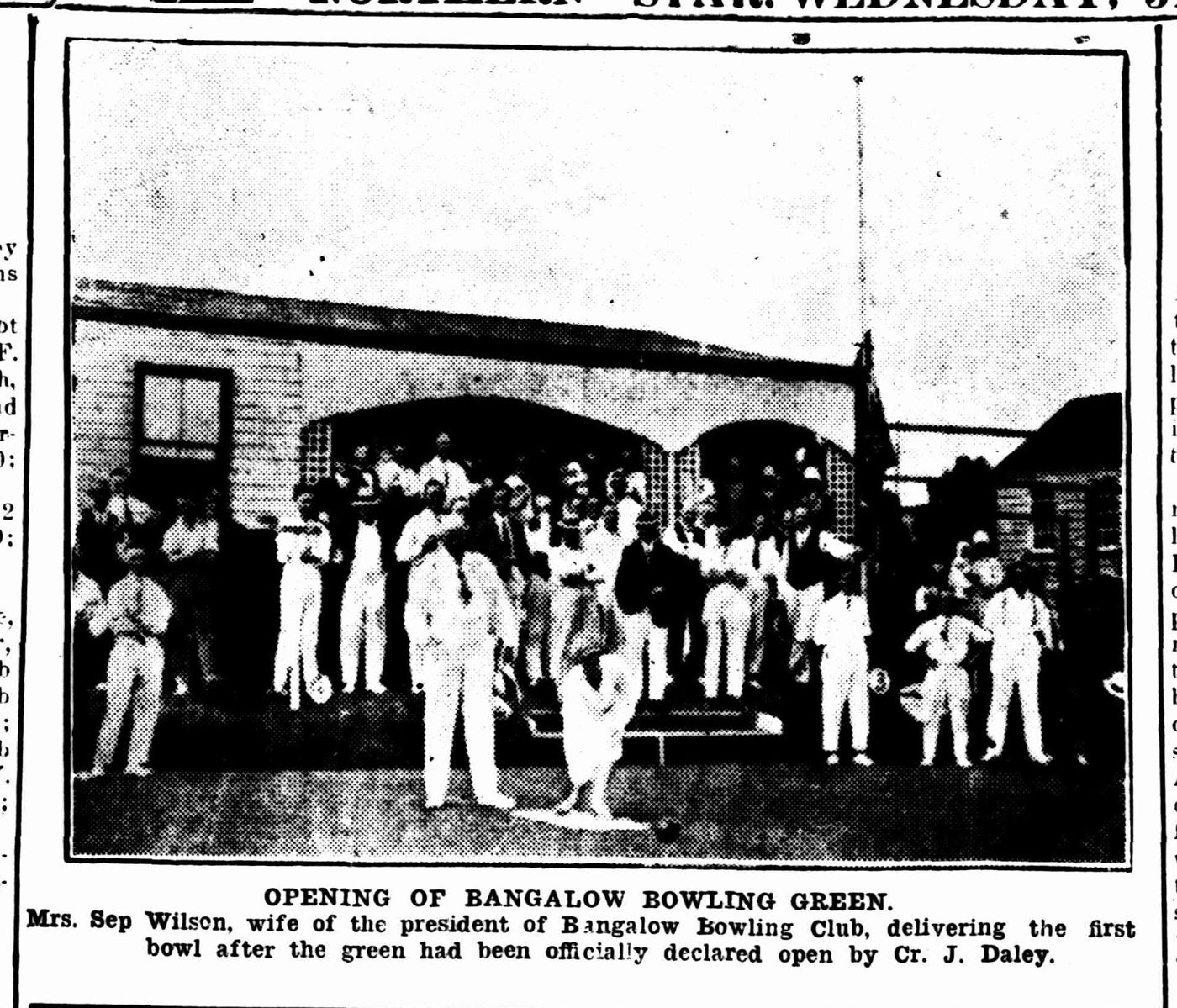 Newspaper photo: Mrs Sep Wilson bowls the first wood in front of the old clubhouse as members in whites look on