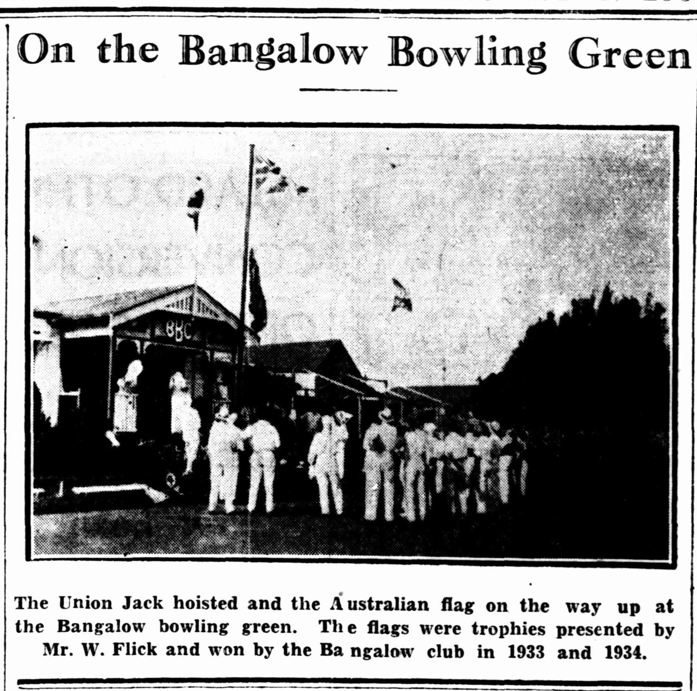 Newspaper photo: flags raised over the Bangalow bowling green beside the pavilion